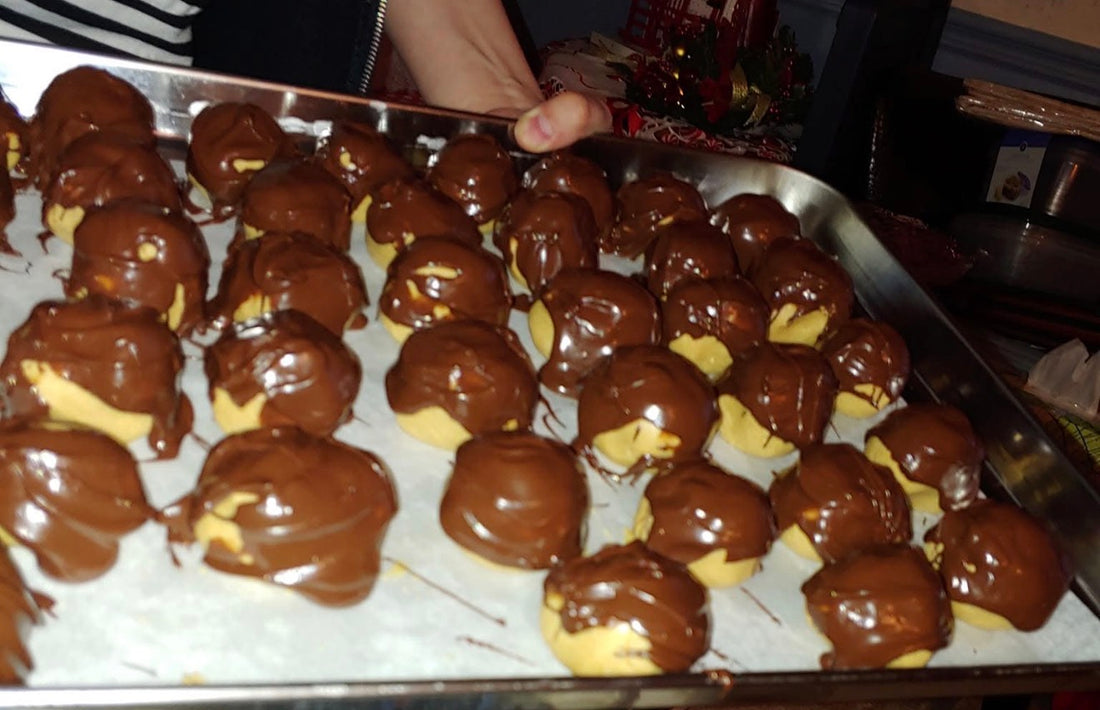 Buckeye peanut butter balls dipped in chocolate on a wax paper lined tray