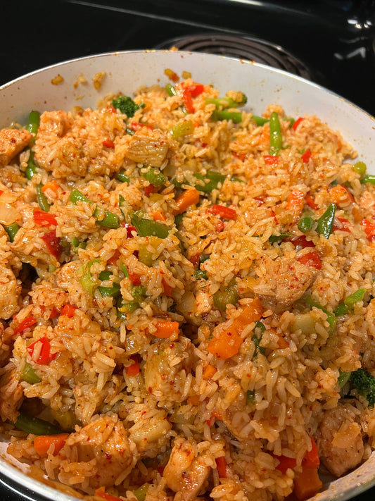 Garlic honey chicken over rice topped with green onions and sesame seeds