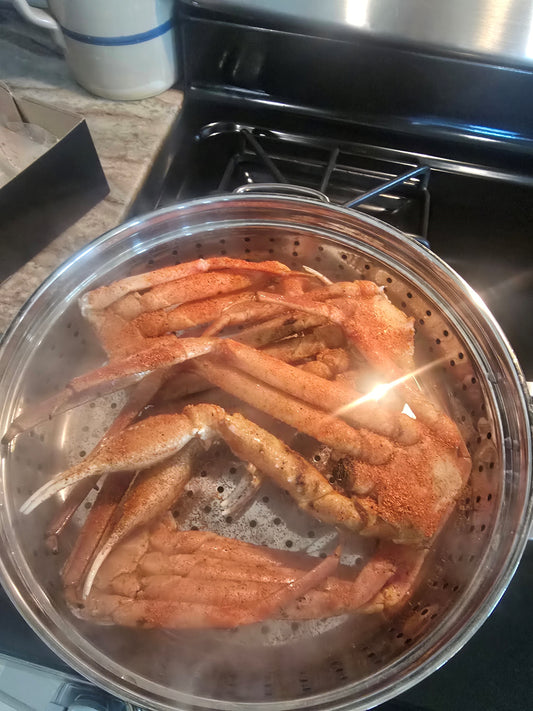 Seasoned steamed crab legs with a bowl of melted butter