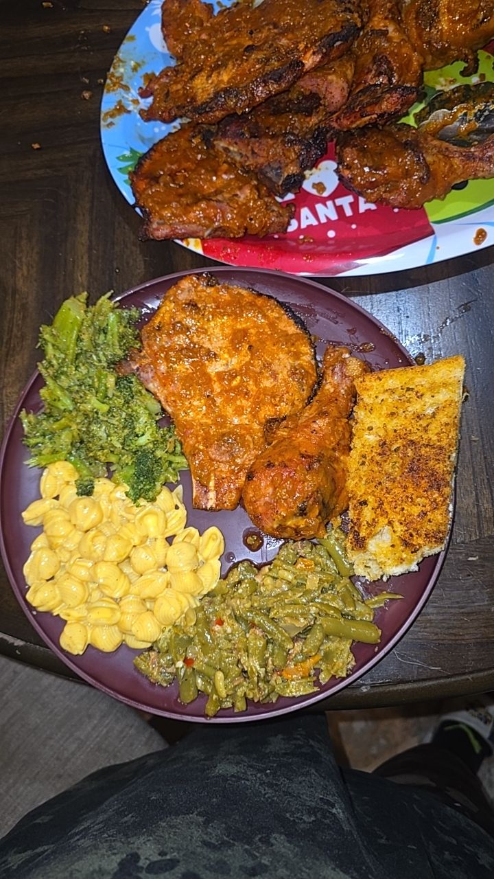 A Sunday plate of BBQ chicken legs and pork chops with broccoli, green beans, mac and cheese and garlic bread