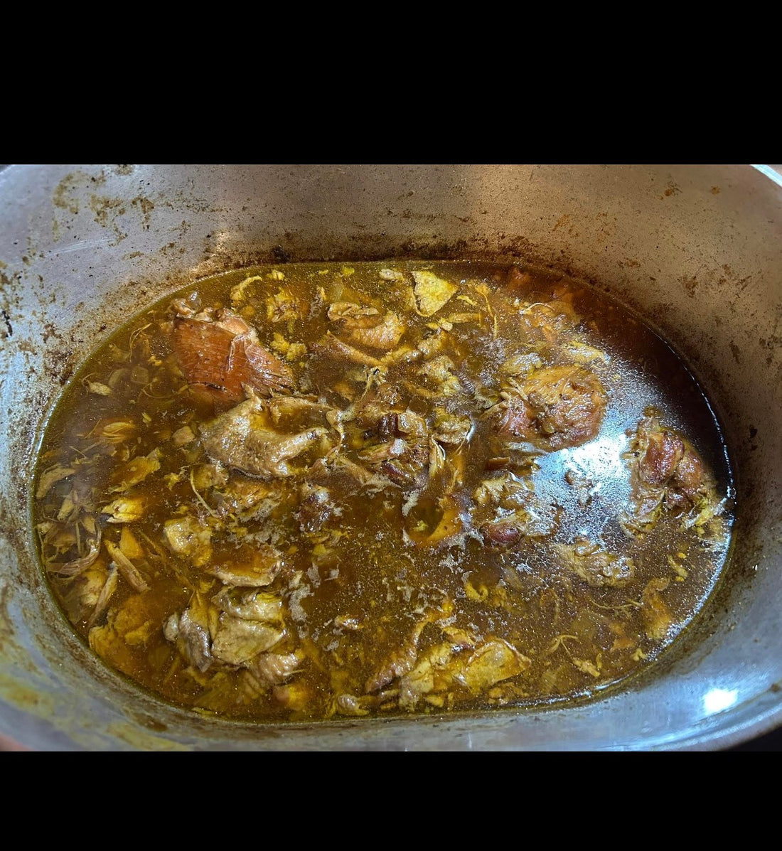 Smothered sticky chicken thighs in dark gravy served over white rice