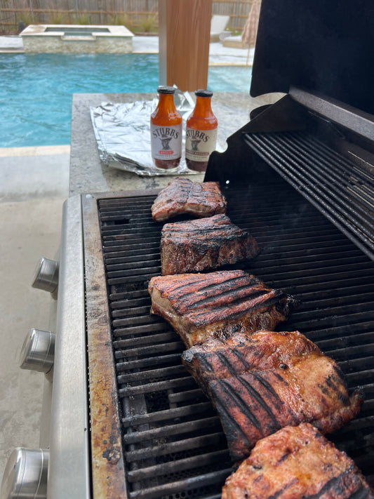 Charred and sauced smoked ribs on the grill