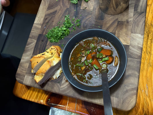A Dutch oven of beef bourguignon with carrots, mushrooms and pearl onions in red wine sauce