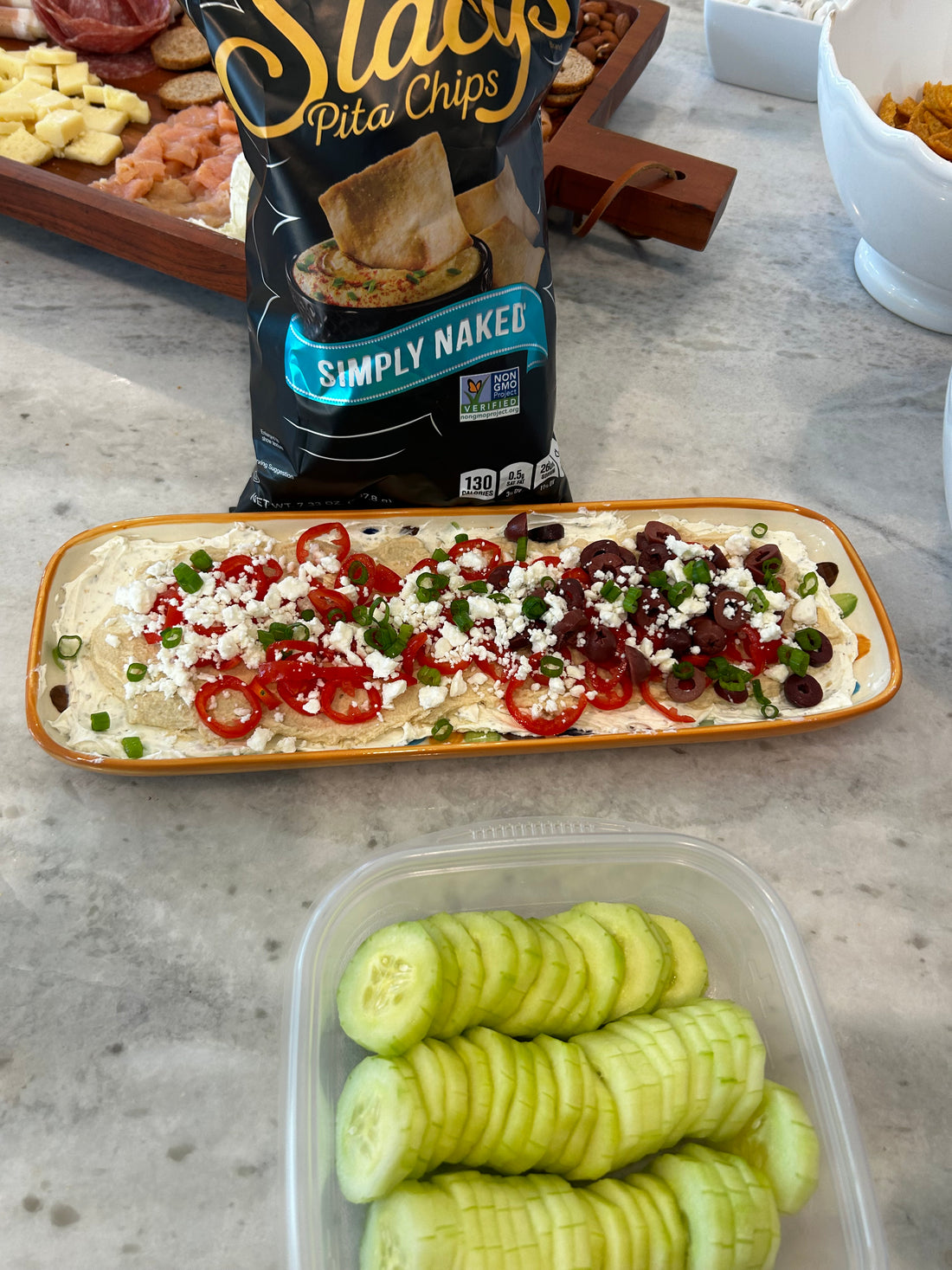 Seven layer Greek dip topped with cucumber, tomato, olives and feta