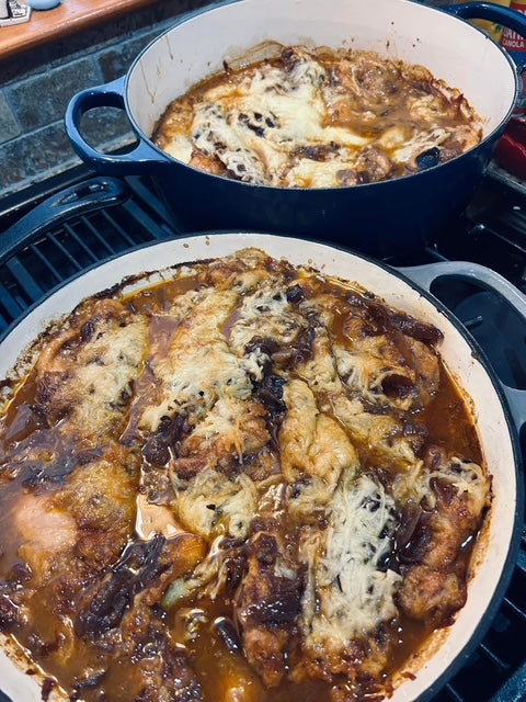 French onion chicken thighs baked in a cast iron skillet under melted mozzarella cheese