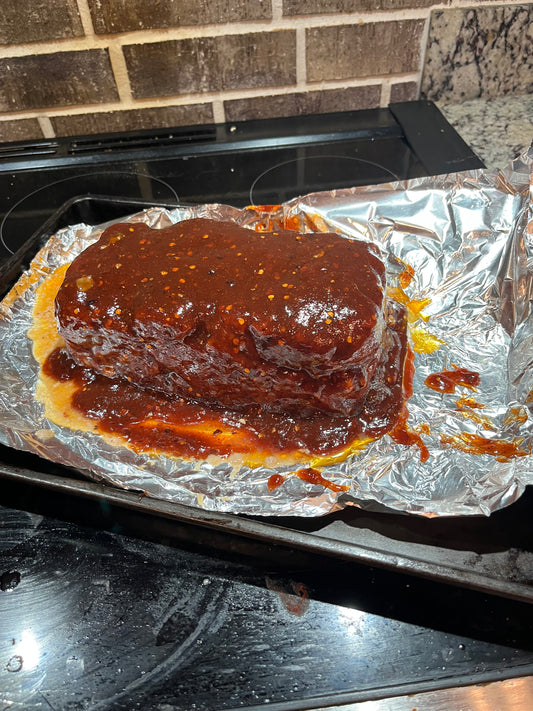 Glazed meatloaf sliced on a cookie sheet