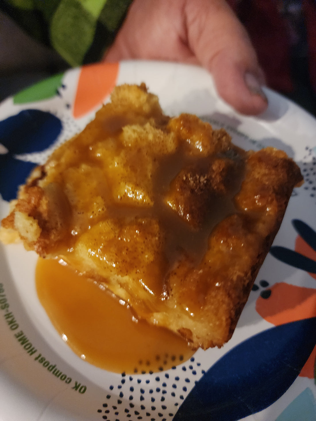 Golden brioche bread pudding in a casserole dish with coconut rum sauce poured over the top