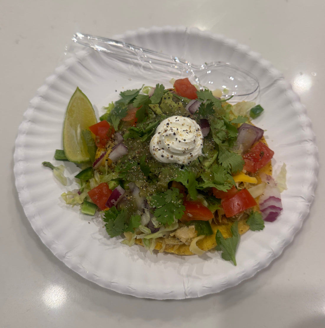 Chicken verde tostadas topped with cheese, lettuce and pico de gallo