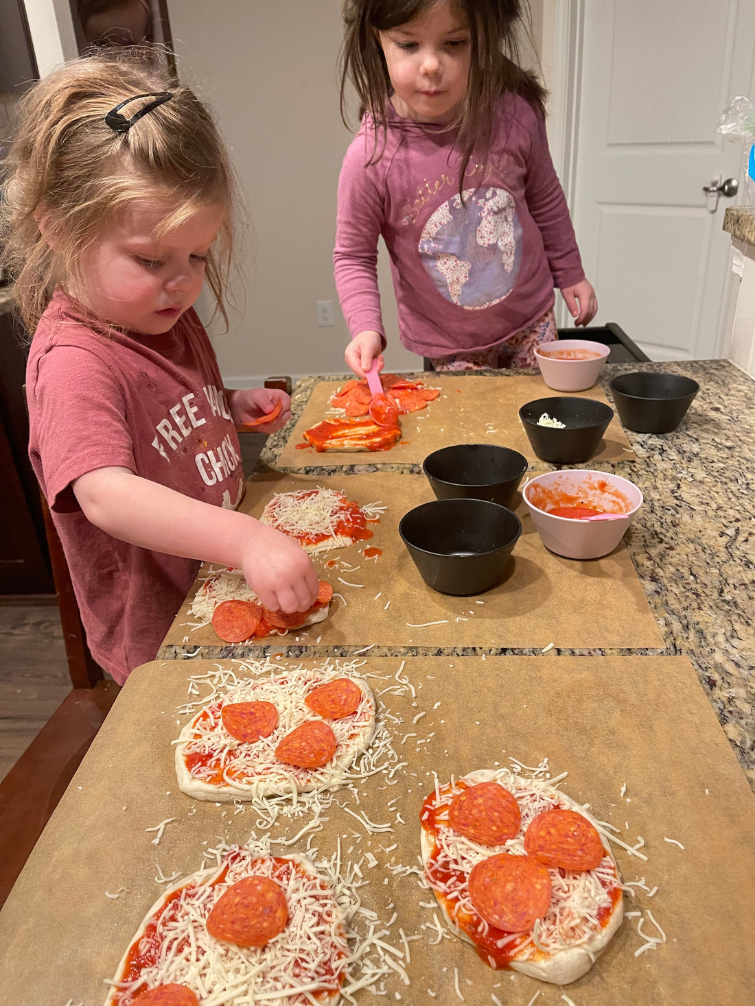 Mini pepperoni pizzas on a parchment lined baking sheet